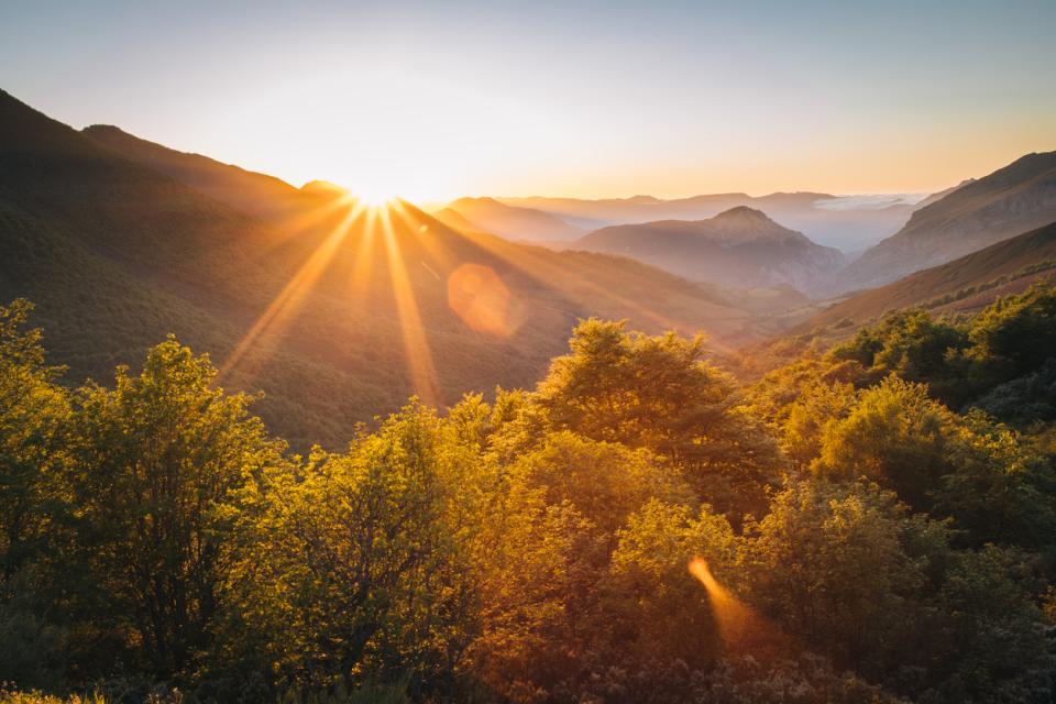 Scenic view of the sun rising over mountains stock photo