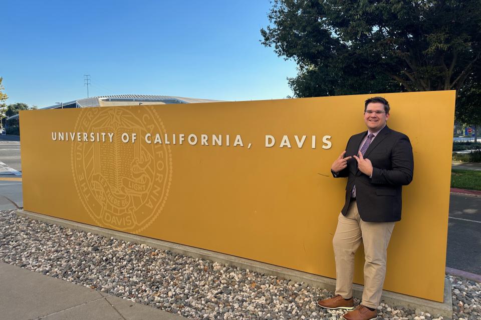 Alex Schultz in front of UC Davis sign