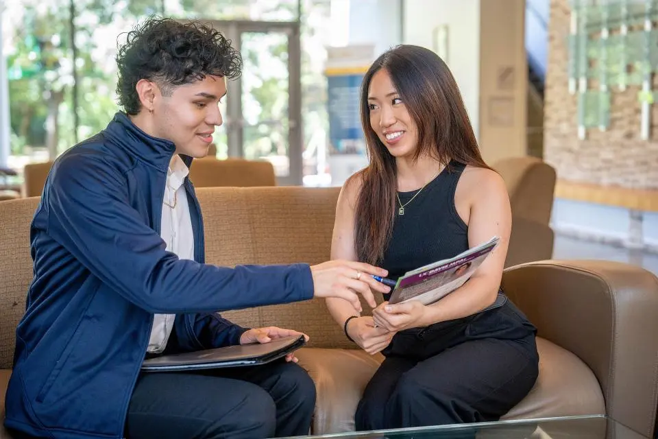 Two MPAc students reviewing a flyer in Gallagher Hall
