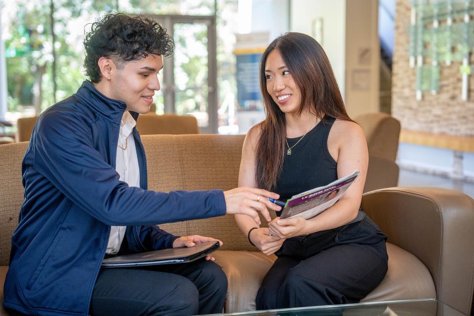 Two MPAc students reviewing a flyer in Gallagher Hall