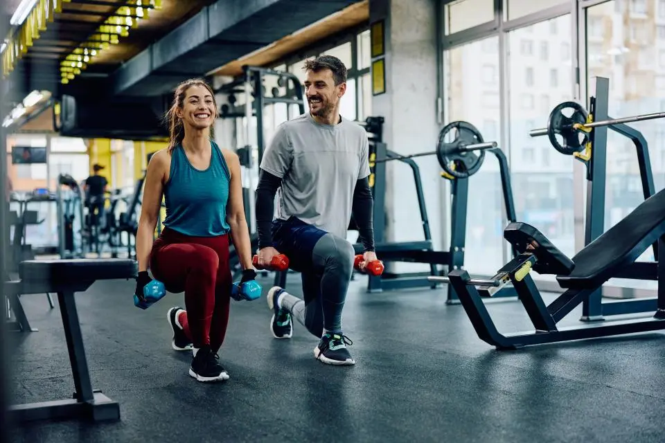 man and woman lifting weights in a gym