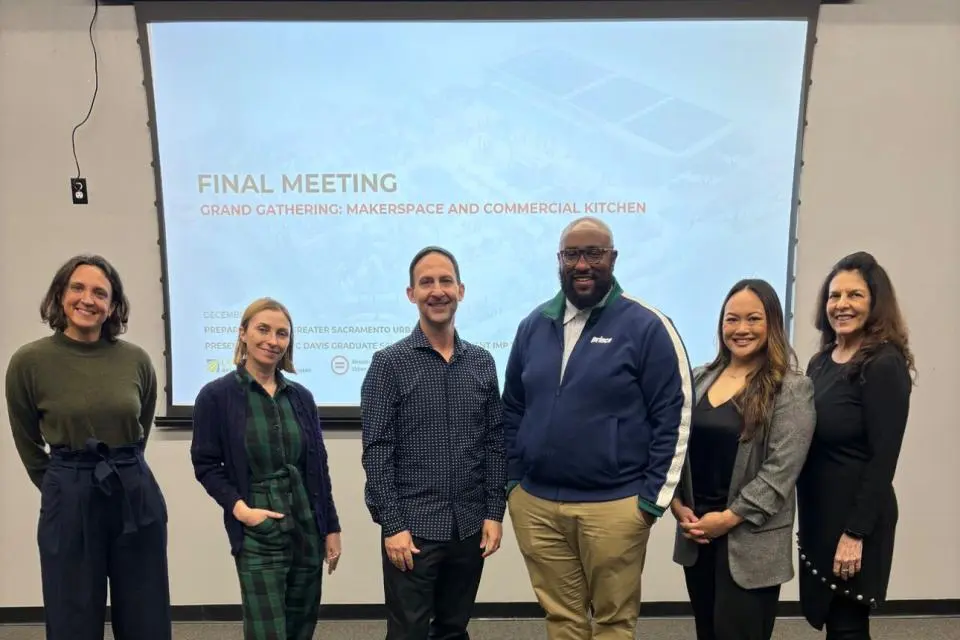 Liza Santa Ana and MBA students in front of a presentation screen