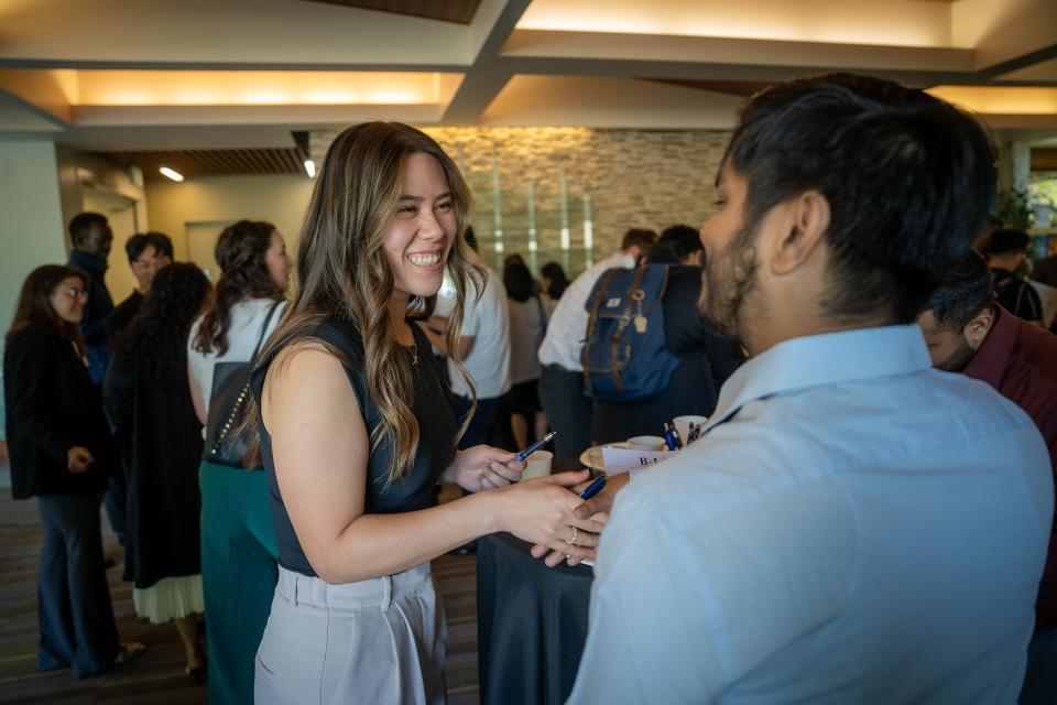 MBA students shaking hands in Gallagher Hall
