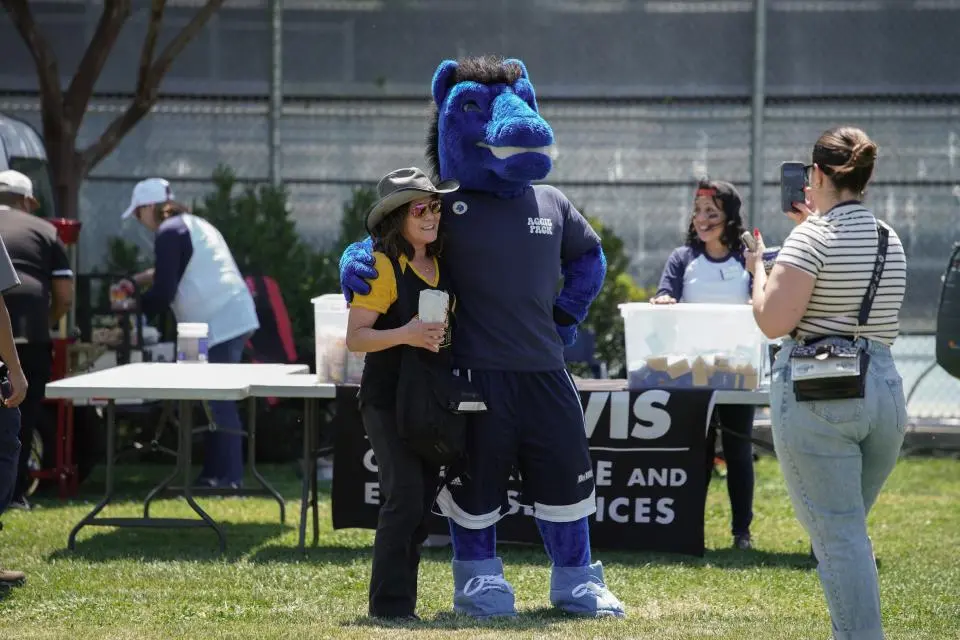Gunrock the mascot and an UC Davis employee standing on Russell Field 