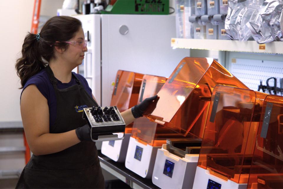 woman standing in front of 3D printers