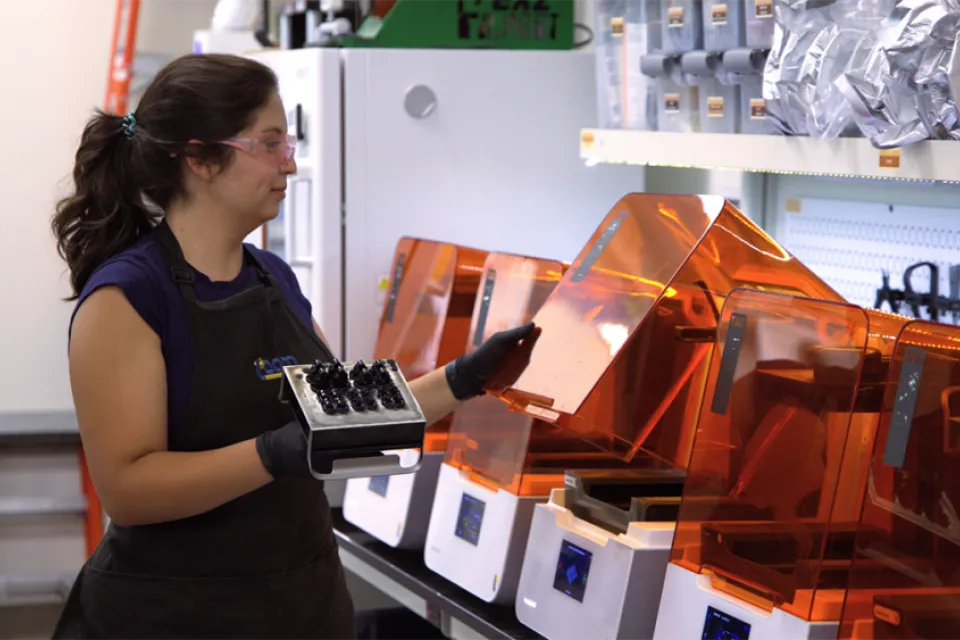 woman standing in front of 3D printers