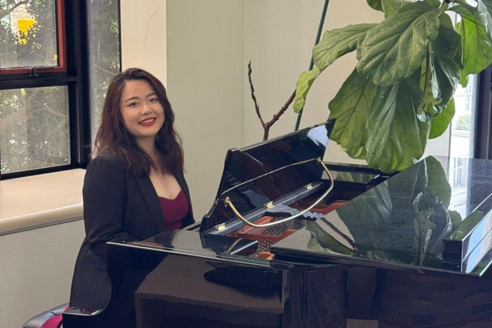Via Lin sitting at a piano