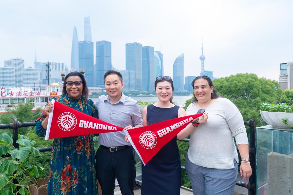 Shannon McPartland and student hold up banners that say Guanghua School of Management.