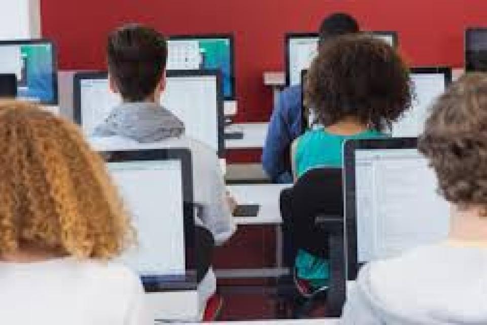 backsides of students on laptops