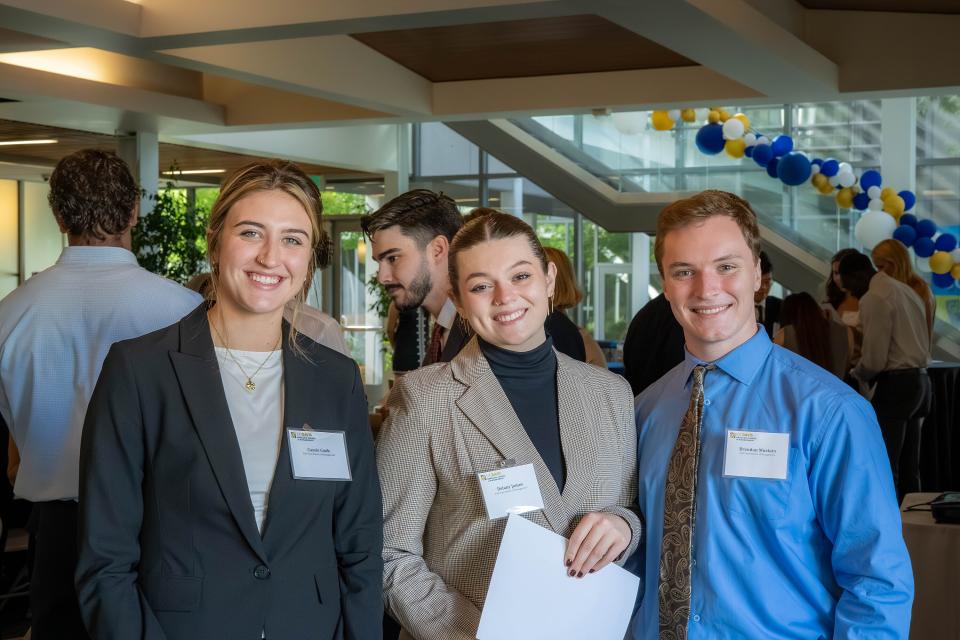 Three students in professional attire in Gallagher Hall