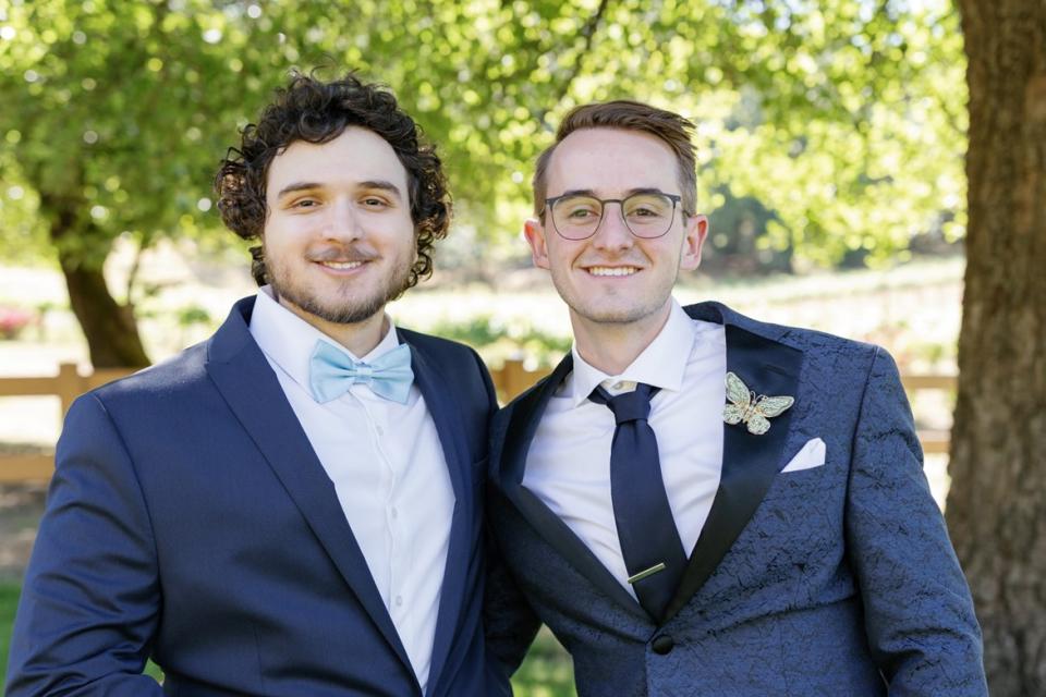 Yamin Elshaer and Dillon Hill standing side-by-side in wedding attire 