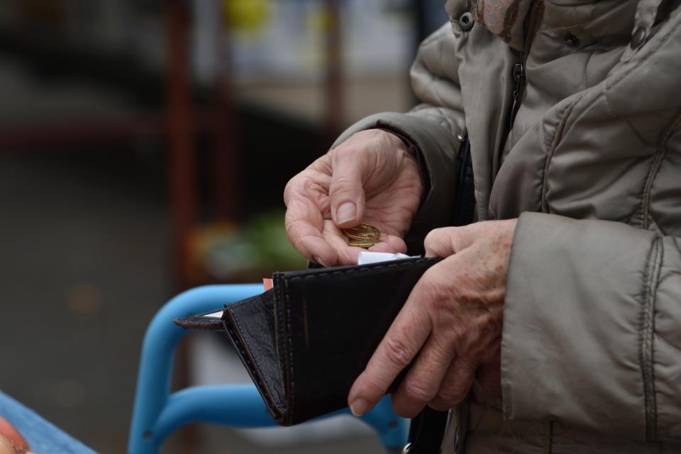 older woman opening a wallet