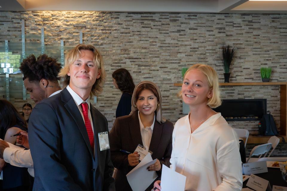 Three Master of Management students dressed in professional attire