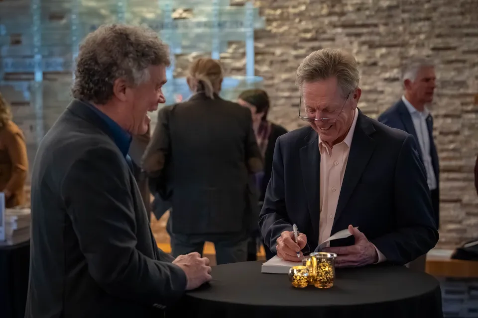 Maurice J. Gallagher Jr. signs copies of his book during a reception at Gallagher Hall after his UC Davis speaker event.