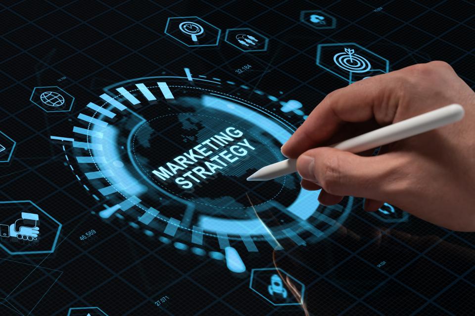 Graphic showing hand writing with pen on computer marketing strategy