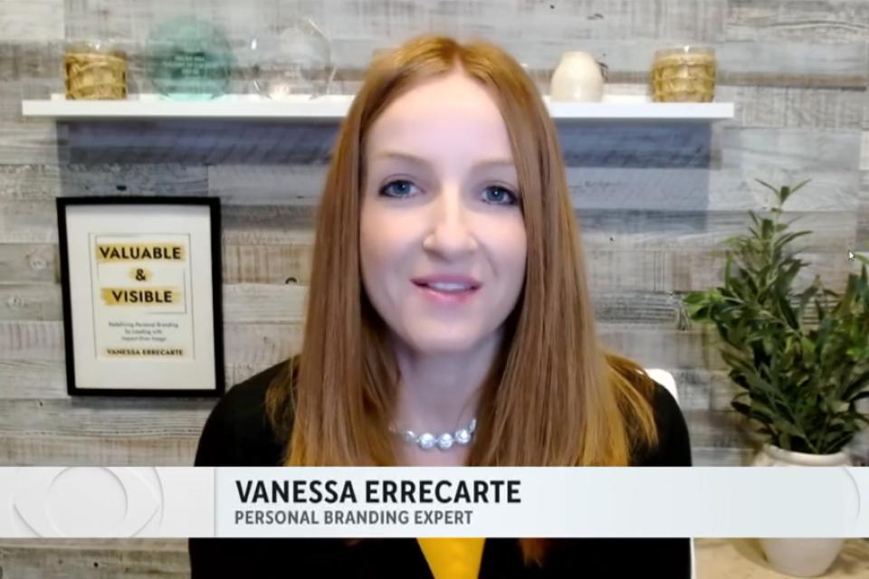 A woman with straight red hair sits in front of shelves with decor and a framed certificate. Text on screen reads "Vanessa Errecarte, Personal Branding Expert.