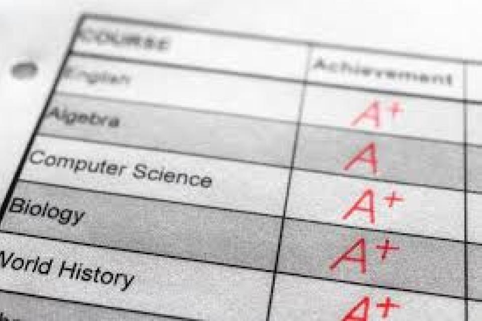 A close-up of a report card showing subjects like Algebra, Computer Science, Biology, and World History with A+ grades in the achievement column.