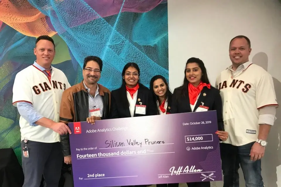 Six people, some wearing Giants jerseys, hold a large ceremonial check for $14,000 awarded to "Silicon Valley Punners" for 2nd place in the Adobe Analytics Challenge.